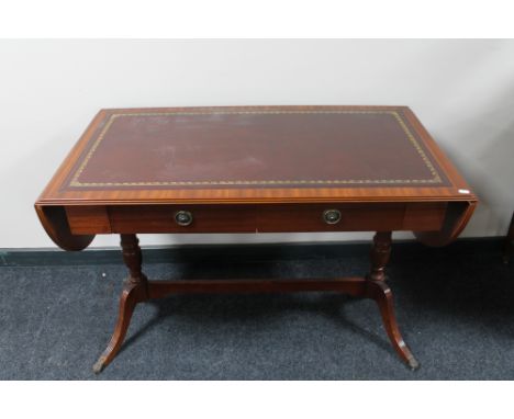 A reproduction mahogany leather topped sofa table with under stretcher 