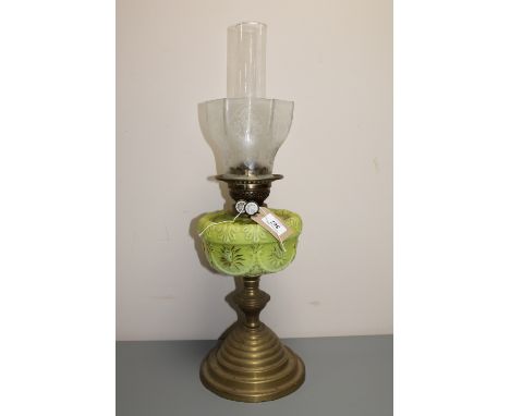 An antique brass oil lamp with a green glass shade CONDITION REPORT: Wear to gilding on shade, otherwise good. 
