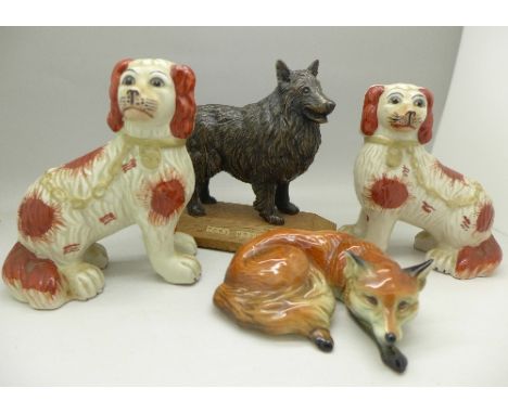 A pair of Staffordshire style spaniels, one a/f, a figure of a fox lying down and a model of a dog