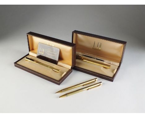 A Dunhill gold plated engine turned fountain pen, nib stamped '750', within fitted case, together with a matching ballpoint p