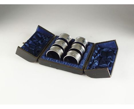 A cased set of six Victorian silver napkin rings, William Eaton, London 1866, each with engine turned decoration and vacant c