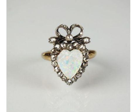 An opal and diamond cluster ring, designed as a central heart shaped opal claw set within a border of rose cut diamonds all s