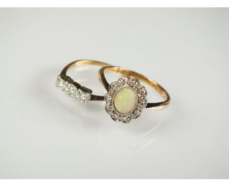 An opal and diamond oval cluster ring, designed as a central cabochon opal within a border of ten faceted diamonds, all milli