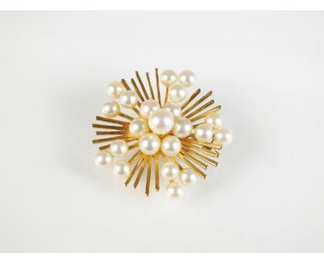 A Mikimoto cultured pearl brooch, designed as a central floral cluster of seven cultured pearls set to yellow metal rayed sun
