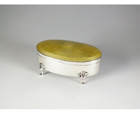 A silver and enamel trinket box, Henry Matthews, Birmingham 1924, of oval form with yellow guilloche enamel cover, opening to