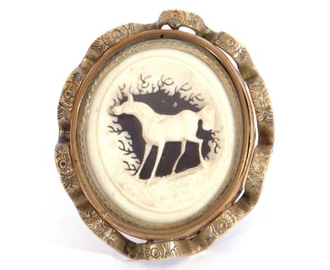 Late 19th century carved ivory brooch, the inner carved with a horse amongst trees in an ornate heavy gilt metal frame, verso