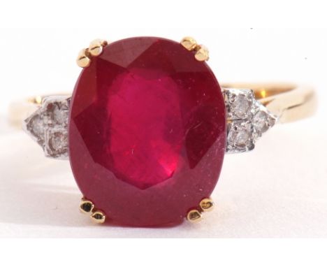 18ct gold, ruby and diamond ring, the large oval faceted ruby four claw set and raised between small diamond set shoulders, d