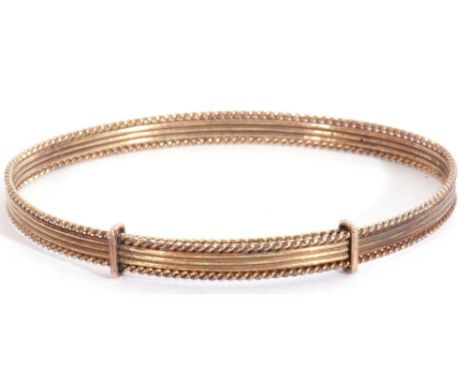 9ct gold expandable bangle, oval shaped with a reeded frame with rope twist border, Birmingham 1987, maker"s mark Bracelon Lt