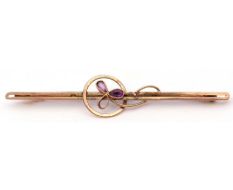 9ct stamped amethyst brooch of open work design, centring an amethyst set flower (one stone missing) on a pierced bar, 5.5cm 