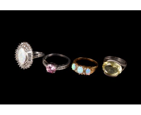 A group of four gem set dress rings, including a silver gilt three stone opal ring, a large opal and CZ ring, a silver and ci