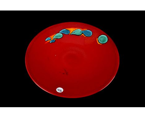 A modern Poole pottery charger,  with matt black ground and 'lava' drop detail, 27cm diameter, together with a larger  red gr