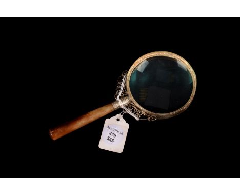A jade handled Chinese white metal magnifying glass, 8cm glass with decorative surround and filigree work to handle attachmen