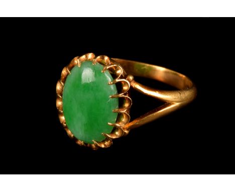 A Chinese jade ring, of oval shape, with claw setting, yellow metal with Chinese strike marks to inner shank, stone 12mm by 0