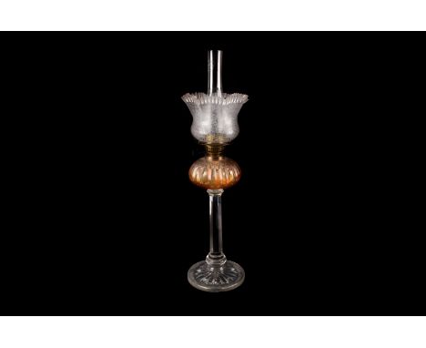 A large glass paraffin lamp, having florally decorated frosted glass shade, with amber coloured well on thick glass column ba