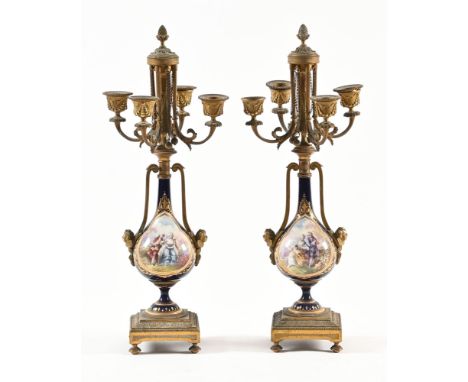 A pair of continental candelabra, with porcelain bodies decorated with panels of courting couple and to the opposite side lan