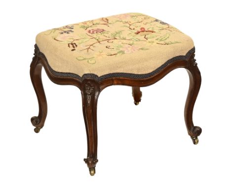 A Victorian tapestry topped stool, raised on four legs on brass castors.  Height 39 cm, width 45 cm, depth 40 cm.