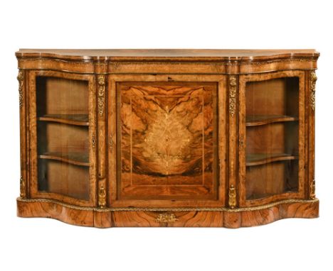 A Victorian walnut credenza, with a serpentine inlaid top with ormolu decoration with a central inlaid cupboard door with vel