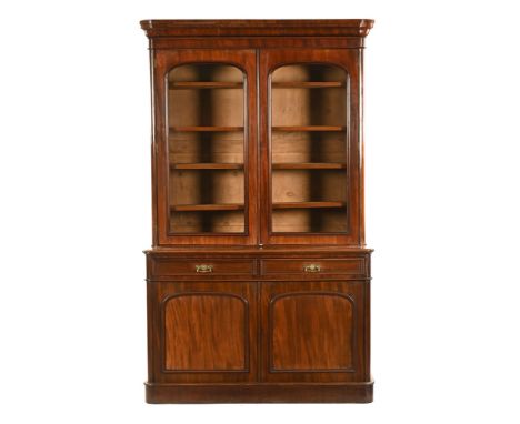 A Victorian mahogany bookcase on cupboard, with a pair of arched doors with four internal adjustable shelves, the base with t