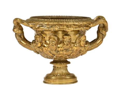 A 19th century bronze urn, relief moulded with principally bearded heads.  Height 14 cm, top diameter 15 cm.