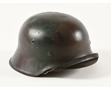 A German World War II M41 camouflage helmet, with leather liner and strap, the liner marked 58.