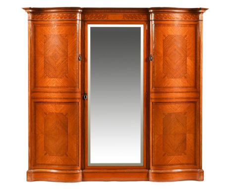 A fine quality Edwardian inlaid satinwood serpentine fronted wardrobe, with detachable moulded cornice above a central mirror
