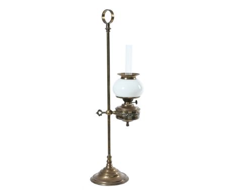 An early 20th century students type oil lamp, with brass stand reservoir and with milk glass shade. Overall height 73 cm.This