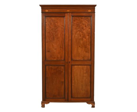 A 19th century inlaid mahogany wardrobe, with detachable moulded cornice above a pair of panelled doors opening to hanging sp