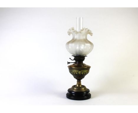 A Victorian brass oil lamp with circular burner, Lampe Veritas marked on the burner with shade and chimney.