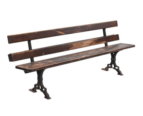 A Victorian bench, possibly from a railway station with wooden seat and back and cast iron frame, with rear trough the ends s