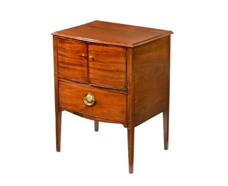 A mahogany commode style bedside cabinet, fitted with a pair of panelled cupboard doors above a dummy drawer and raised on ta