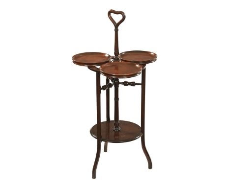 An early 20th century revolving cake stand, with centre carrying handle and low shelf.&nbsp; Height 94 cm, width 48 cm.