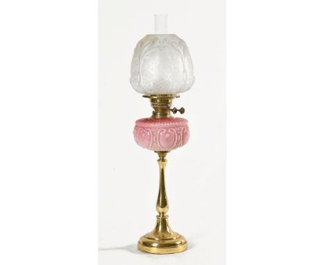 A Victorian oil lamp, with brass base pink glass reservoir and clear glass floral encrusted shade. Height excluding chimney 6