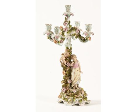 A continental porcelain candelabra, the base decorated with flowers and maiden with winged cherub and having four branches fi