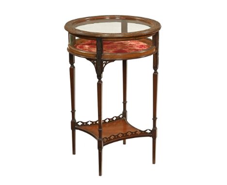 An Edwardian mahogany bijouterie table, the circular top with blind fretwork edge and with glazed panels all round raised on 