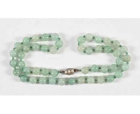 A strap of jade beads, with simulated pearl clasp.  Length 72 cm.