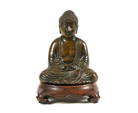 A 20th century bronze Buddha, with associated oriental vase stand.&nbsp; Buddha height 18.5 cm.