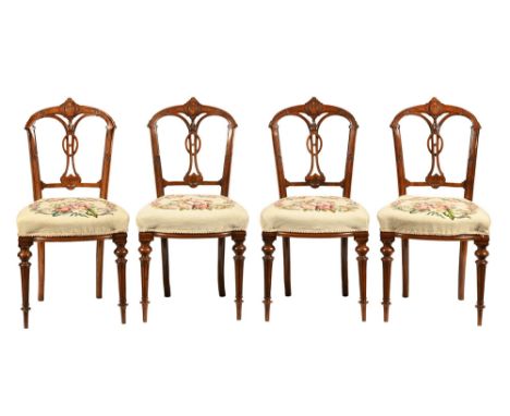 A set of four Victorian walnut occasional or dining chairs, each with carved show frames, wool work tapestry stuffover seats 