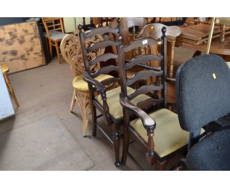A pair of ladder back carver chairs; together with a wicker chair 