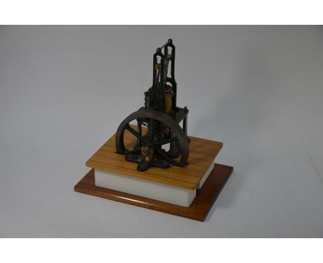 A 1 inch engineering scale model steam table engine, painted dark green, with 18 cm dia. wheel, model 33 cm h o/all on wood s