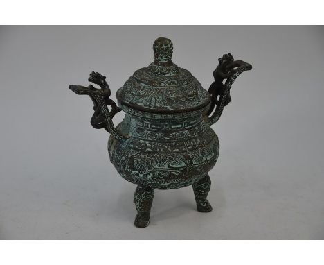 A Chinese brass censer and cover in the archaic manner, with twin dragon-mounted handles, richly chased and embossed overall 