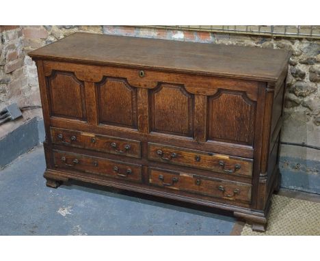 An 18th century Lancashire mahogany cross-banded oak mule chest, the hinged top over four arched panels and two over two shor