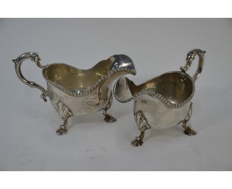 A heavy quality pair of silver sauce boats in the Georgian manner, with gadrooned rims, scroll handles and scrolling shell fe
