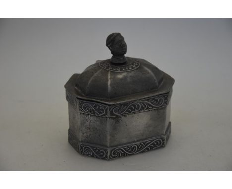 A 19th century lead tobacco box, the domed cover with African-head finial, internal plate-weight, 13 cm wide