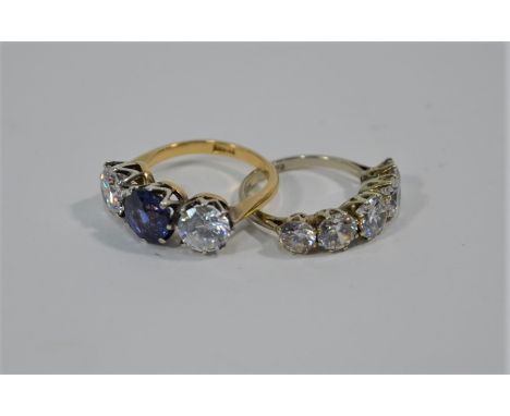 A three stone ring, the central stone a claw set blue sapphire (probably) flanked by two claw set pastes, 18ct yellow gold se