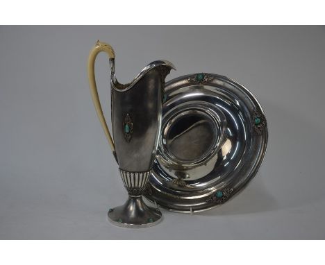 A Continental Art Deco white metal ewer and basin set with turquoise bosses in foliate scrolling mounts, the slender ewer wit