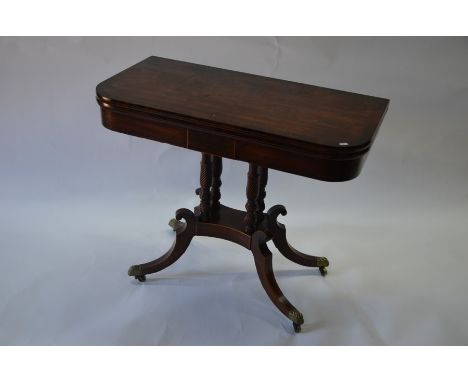 A Regency mahogany and rosewood cross-banded D-end folding card table with brass stringing, on four turned and spiral-reeded 