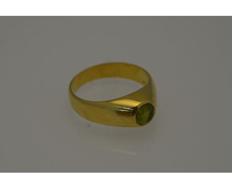 A yellow metal ring set with single circular peridot, size S/T, approx 7.7g all in