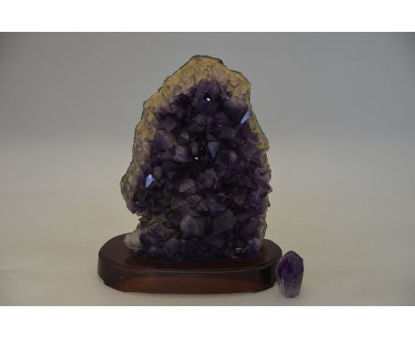 An amethyst geode, 27 x 20 cm overall, fitted with wooden base, to/w a large loose amethyst crystal