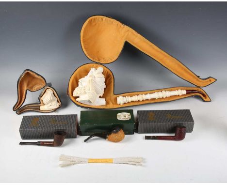 An oversized late 20th century carved meerschaum pipe, cased, another cased meerschaum pipe and three other smoking pipes, on