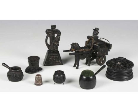 A group of Irish bog oak souvenirs, including a carved harp, inscribed 'Erin', height 9.5cm, and a pin cushion of cooking pot